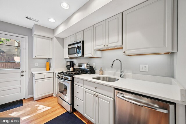 104 S St, Annapolis, MD 21401 - kitchen featuring stainless steel appliances, a sink, light countertops, white cabinetry, and recessed lighting