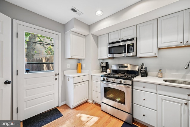 104 S St, Annapolis, MD 21401 - kitchen with stainless steel appliances, a sink, white cabinets, light countertops, and recessed lighting