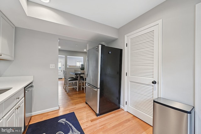 104 S St, Annapolis, MD 21401 - kitchen with stainless steel appliances, light wood finished floors, light countertops, white cabinets, and baseboards