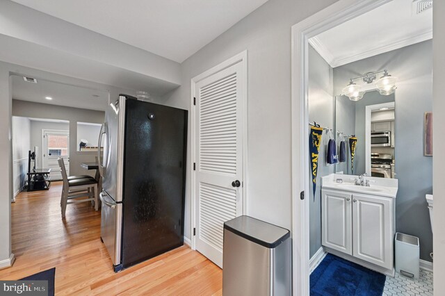 104 S St, Annapolis, MD 21401 - kitchen featuring stainless steel appliances, a sink, baseboards, and light wood-style floors