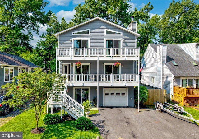 1323 Washington Dr, Annapolis, MD 21403 - view of front facade featuring a garage, asphalt driveway, a chimney, stairway, and a balcony
