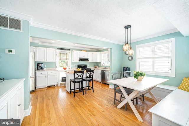 1323 Washington Dr, Annapolis, MD 21403 - dining area featuring ornamental molding, light wood-type flooring, plenty of natural light, and a textured ceiling
