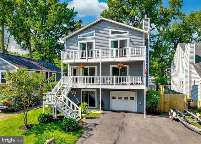 1323 Washington Dr, Annapolis, MD 21403 - view of front of house with a balcony, driveway, a garage, a chimney, and stairs