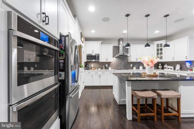 24696 Crested Butte Ct, Aldie, VA 20105 - kitchen featuring appliances with stainless steel finishes, wall chimney range hood, backsplash, white cabinets, and recessed lighting