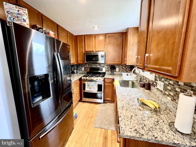 10213 Duvawn Pl, Silver Spring, MD 20902 - kitchen with appliances with stainless steel finishes, brown cabinets, light wood finished floors, backsplash, and recessed lighting