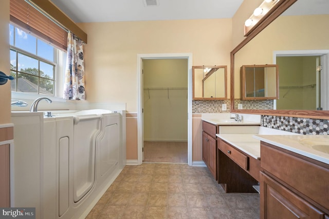 44 Homberg Cir, Dover, DE 19904 - full bath with vanity, a walk in closet, a bath, and decorative backsplash