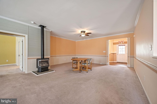 44 Homberg Cir, Dover, DE 19904 - dining space with crown molding, a wood stove, ceiling fan, carpet floors, and wainscoting