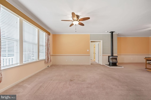 44 Homberg Cir, Dover, DE 19904 - unfurnished living room with a wood stove, ceiling fan, carpet floors, crown molding, and a wainscoted wall