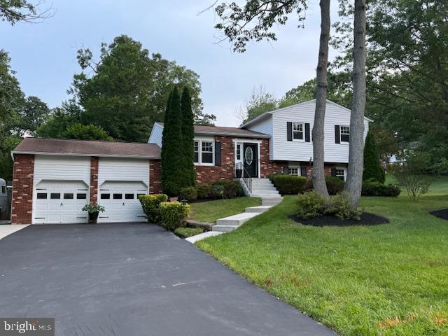 1247 Silver Run Dr, Pasadena, MD 21122 - split level home with a front lawn, brick siding, and driveway