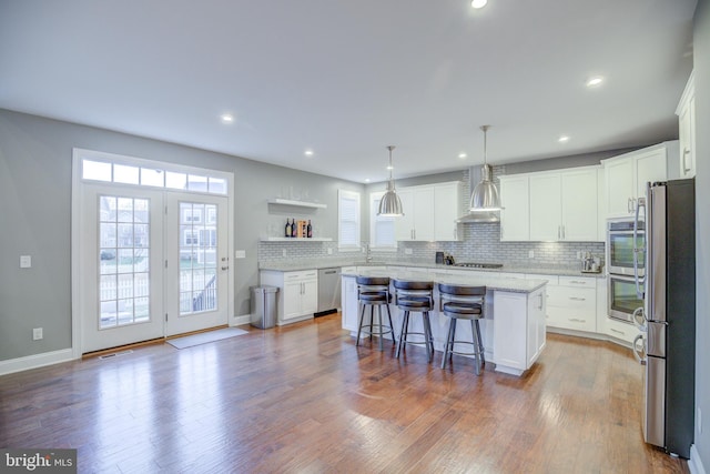41031 Brook Grove Dr, Aldie, VA 20105 - kitchen featuring wall chimney range hood, stainless steel appliances, a center island, plenty of natural light, and recessed lighting