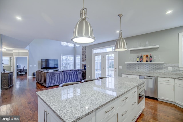 41031 Brook Grove Dr, Aldie, VA 20105 - kitchen with appliances with stainless steel finishes, a center island, backsplash, a stone fireplace, and light stone counters