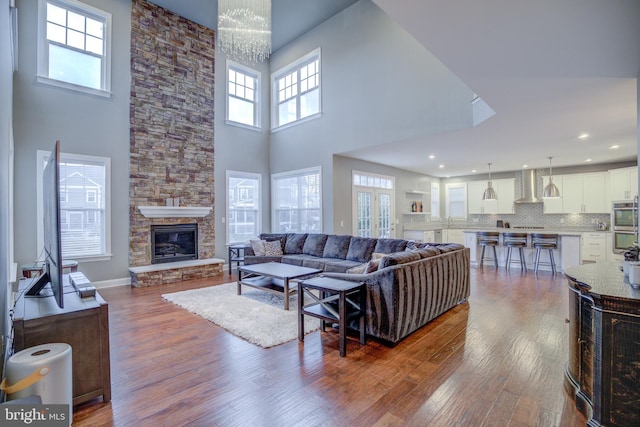 41031 Brook Grove Dr, Aldie, VA 20105 - living room featuring a high ceiling, dark wood-style floors, a fireplace, and baseboards