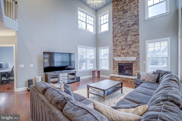 41031 Brook Grove Dr, Aldie, VA 20105 - living area featuring a high ceiling, wood finished floors, baseboards, a chandelier, and a stone fireplace