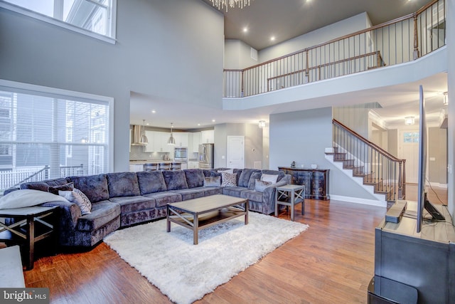 41031 Brook Grove Dr, Aldie, VA 20105 - living room featuring a high ceiling, stairway, light wood finished floors, and baseboards