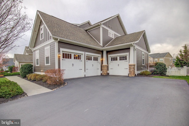 41031 Brook Grove Dr, Aldie, VA 20105 - view of side of property with board and batten siding, asphalt driveway, a shingled roof, and stone siding