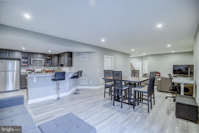 41031 Brook Grove Dr, Aldie, VA 20105 - dining room with light wood-type flooring, bar with sink, recessed lighting, and baseboards