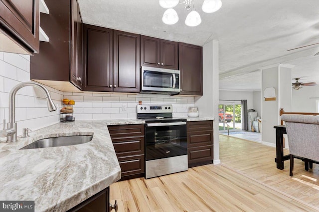 297 Killian Rd, Honey Brook, PA 19344 - kitchen featuring stainless steel appliances, light wood-type flooring, dark brown cabinets, light stone counters, and backsplash