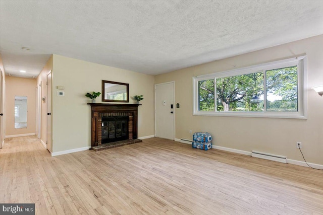 297 Killian Rd, Honey Brook, PA 19344 - unfurnished living room with a baseboard radiator, light wood finished floors, a brick fireplace, and a textured ceiling