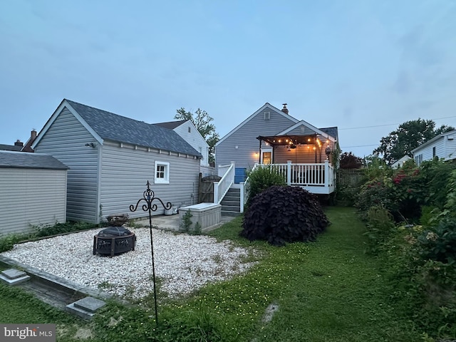 3234 Glendale Ave, Baltimore, MD 21234 - back of house with a fire pit, an outbuilding, a lawn, stairs, and roof with shingles