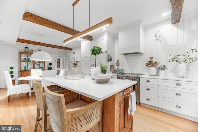 3209 Henson Ave, Annapolis, MD 21403 - kitchen with stainless steel electric range oven, backsplash, custom range hood, a kitchen breakfast bar, and light wood-type flooring