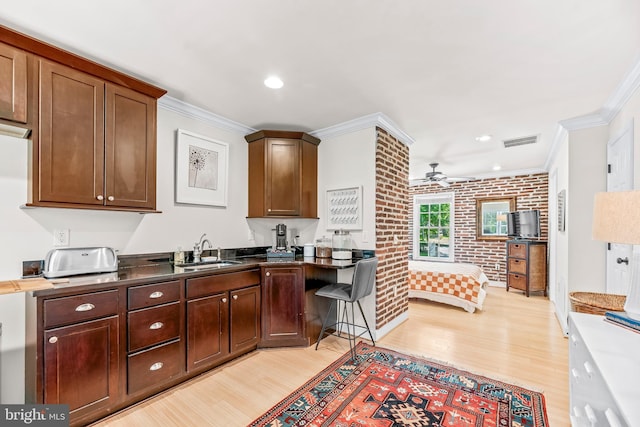 3209 Henson Ave, Annapolis, MD 21403 - kitchen with crown molding, light wood finished floors, a ceiling fan, brick wall, and recessed lighting