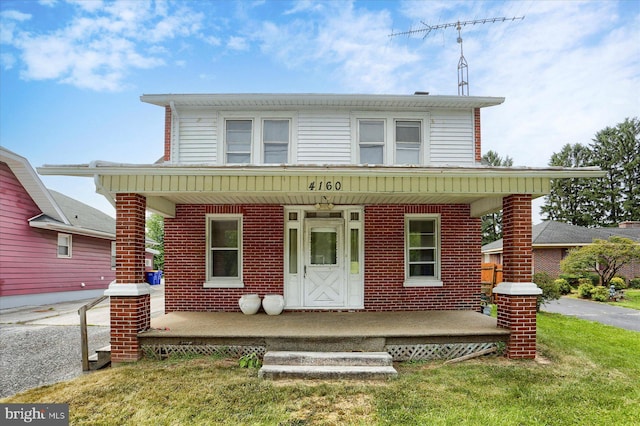 4160 W Market St, York, PA 17408 - view of front of home with covered porch, brick siding, and a front lawn