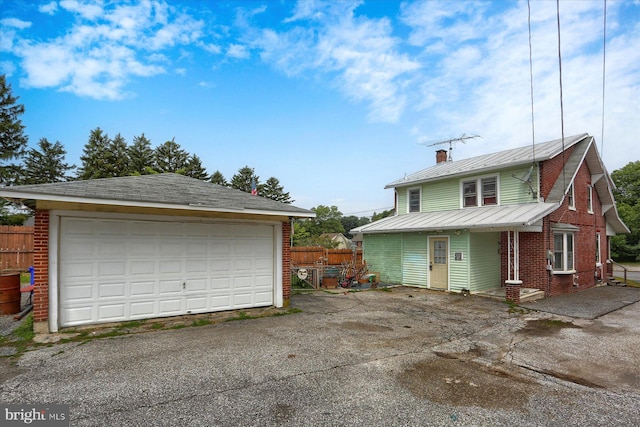 4160 W Market St, York, PA 17408 - view of front of property featuring a garage, brick siding, a chimney, metal roof, and an outdoor structure