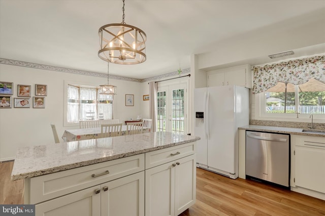 143 Brittany Dr, Chalfont, PA 18914 - kitchen featuring stainless steel dishwasher, white fridge with ice dispenser, a chandelier, light wood-style flooring, and white cabinetry