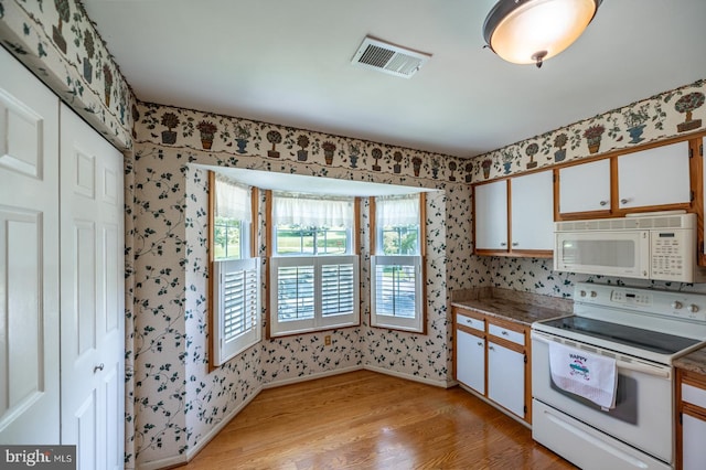 722 Scotch Way Unit C-26, West Chester, PA 19382 - kitchen featuring white appliances, wallpapered walls, light wood-type flooring, healthy amount of natural light, and white cabinetry