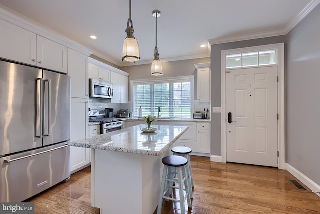 2149 Colleens Way, Lancaster, PA 17601 - kitchen with appliances with stainless steel finishes, crown molding, white cabinetry, light wood-style floors, and light stone counters
