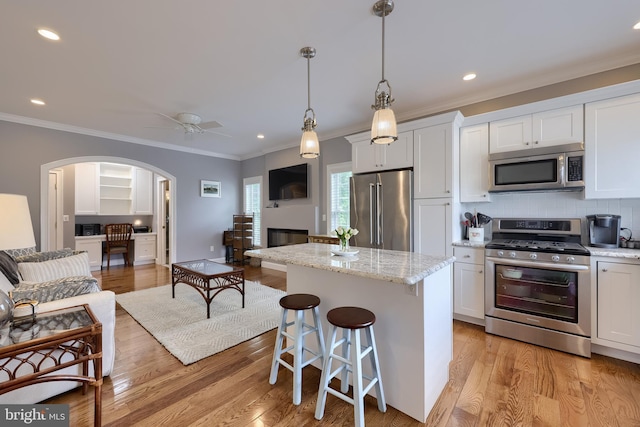 2149 Colleens Way, Lancaster, PA 17601 - kitchen with appliances with stainless steel finishes, open floor plan, a center island, arched walkways, and ornamental molding