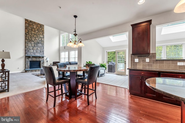 3913 Rolling Paddock Dr, Upper Marlboro, MD 20772 - dining room with a skylight, a stone fireplace, dark wood-style floors, and plenty of natural light