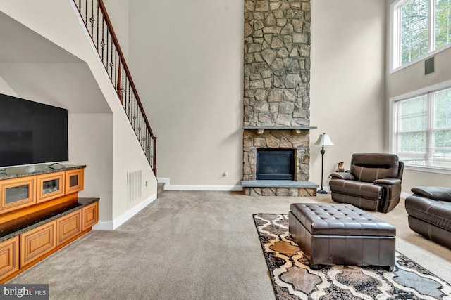 3913 Rolling Paddock Dr, Upper Marlboro, MD 20772 - carpeted living room with a towering ceiling, baseboards, a stone fireplace, and stairs