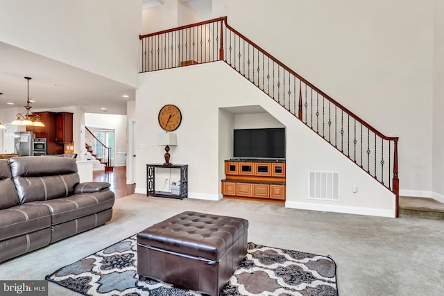 3913 Rolling Paddock Dr, Upper Marlboro, MD 20772 - living room featuring light colored carpet, stairway, a high ceiling, a chandelier, and baseboards