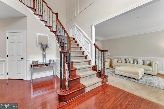3913 Rolling Paddock Dr, Upper Marlboro, MD 20772 - stairs with wood finished floors, wainscoting, crown molding, and a towering ceiling