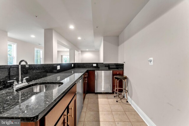 3913 Rolling Paddock Dr, Upper Marlboro, MD 20772 - kitchen with refrigerator, a sink, light tile patterned floors, dark stone countertops, and recessed lighting