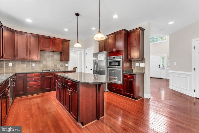 3913 Rolling Paddock Dr, Upper Marlboro, MD 20772 - kitchen featuring reddish brown cabinets, hardwood / wood-style flooring, a center island, wainscoting, and recessed lighting