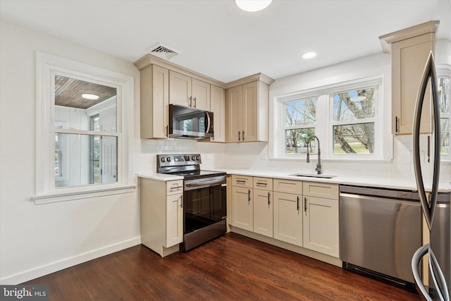 1631 Old Schuylkill Rd, Spring City, PA 19475 - kitchen with appliances with stainless steel finishes, dark wood-style floors, light countertops, tasteful backsplash, and cream cabinets