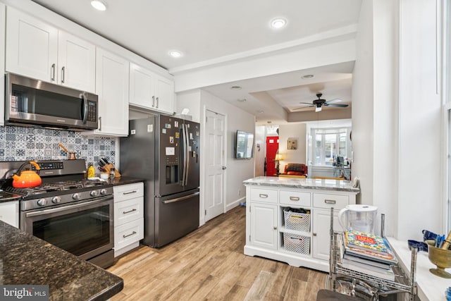 1523 N Hollywood St, Philadelphia, PA 19121 - kitchen with appliances with stainless steel finishes, white cabinets, backsplash, light wood-style floors, and a ceiling fan