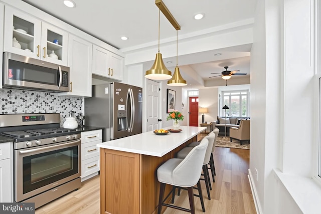 1523 N Hollywood St, Philadelphia, PA 19121 - kitchen with appliances with stainless steel finishes, light wood finished floors, white cabinets, a breakfast bar area, and recessed lighting