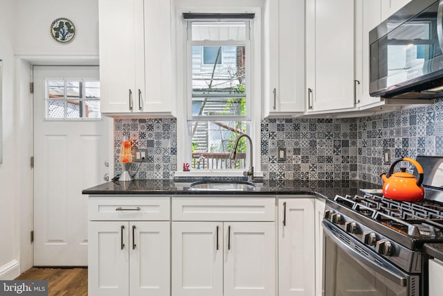 1523 N Hollywood St, Philadelphia, PA 19121 - kitchen with a sink, gas range, white cabinetry, wood finished floors, and dark stone counters