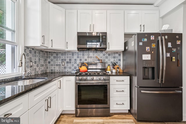 1523 N Hollywood St, Philadelphia, PA 19121 - kitchen featuring appliances with stainless steel finishes, a sink, white cabinetry, and dark stone counters