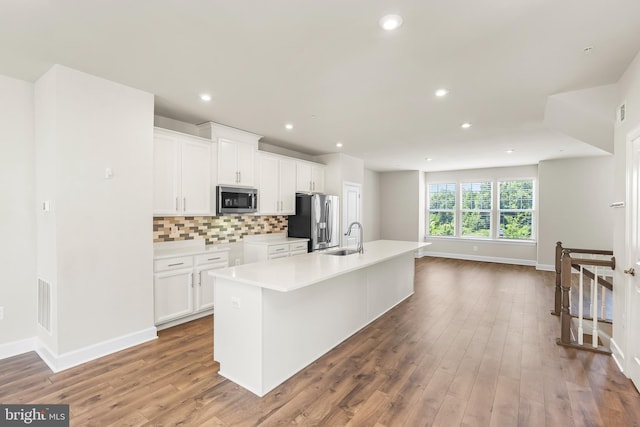 2270 Haw River Rd, Hanover, MD 21076 - kitchen featuring stainless steel appliances, a sink, baseboards, a center island with sink, and white cabinetry