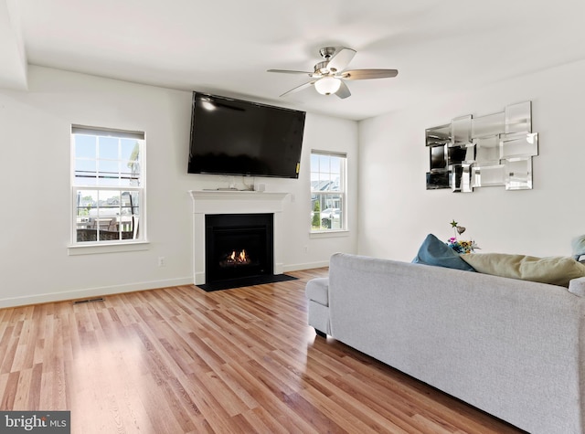 11 Kestrel Dr, Mechanicsburg, PA 17050 - living area featuring light wood-type flooring, a ceiling fan, a fireplace with flush hearth, and baseboards