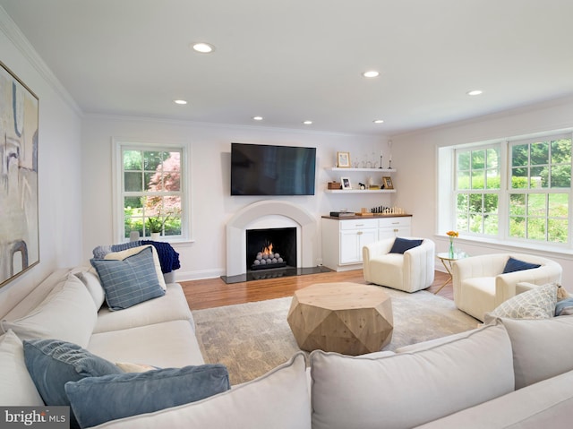 745 Conestoga Rd, Bryn Mawr, PA 19010 - living area featuring crown molding, healthy amount of natural light, light wood-type flooring, recessed lighting, and a lit fireplace
