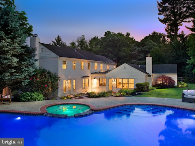 745 Conestoga Rd, Bryn Mawr, PA 19010 - pool at dusk with a patio area, a yard, and a pool with connected hot tub