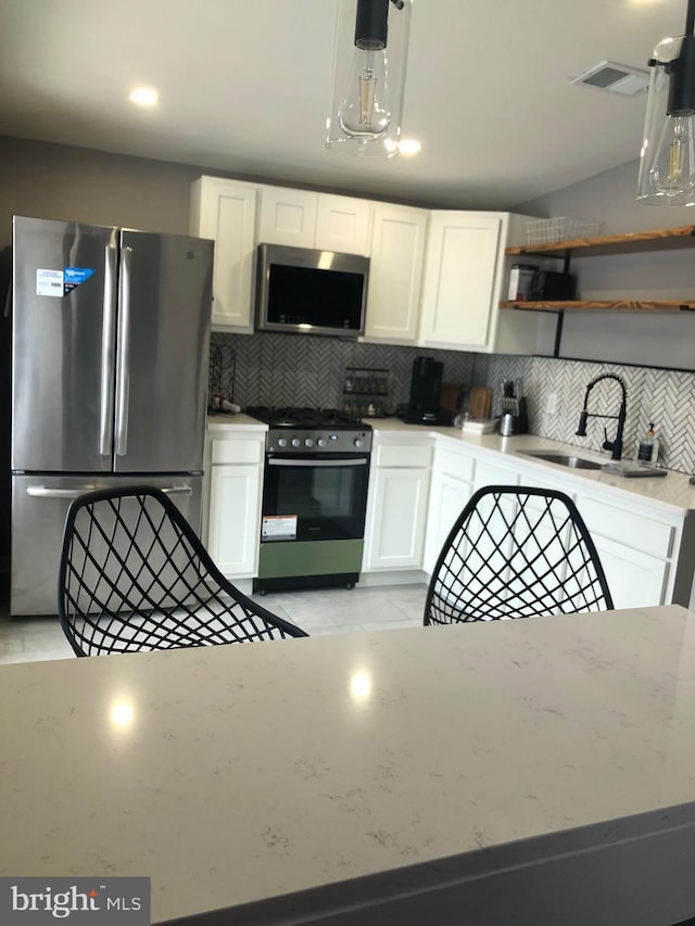 300 Darcy Ave, Hamilton, NJ 08629 - kitchen featuring appliances with stainless steel finishes, a sink, tasteful backsplash, and white cabinetry