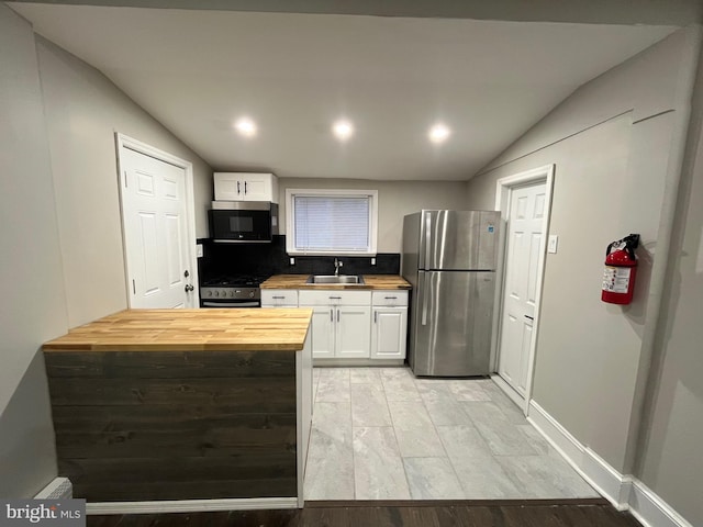 300 Darcy Ave, Hamilton, NJ 08629 - kitchen with wood counters, appliances with stainless steel finishes, vaulted ceiling, a sink, and white cabinetry