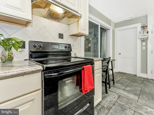 19330 Longmeadow Rd, Hagerstown, MD 21742 - kitchen featuring black range with electric cooktop, under cabinet range hood, tasteful backsplash, and light countertops