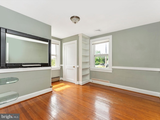 19330 Longmeadow Rd, Hagerstown, MD 21742 - unfurnished bedroom featuring hardwood / wood-style flooring, baseboards, multiple windows, and a baseboard radiator